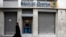 A Greek Orthodox priest walks a branch of Bank of Cyprus in Athens March 19, 2013.
