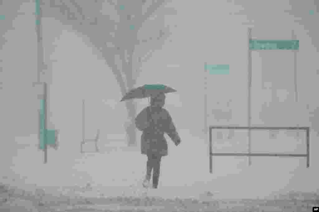 Uma pessoa segura um guarda-chuva enquanto caminha durante uma tempestade de inverno, a 6 de janeiro de 2025, em Cincinnati, Ohio.