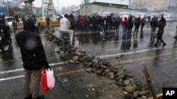FILE - A road is blocked by protesters after authorities raised gasoline prices, in Tehran, Iran, Nov. 16, 2019.
