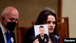 Belarusian opposition leader Sviatlana Tsikhanouskaya shows a photograph as she speaks at Czech Senate in Prague, Czech Republic, June 9, 2021. 