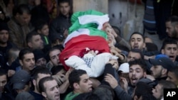 Palestinian mourners carry the body of Bilal Zayed, 23, who was killed in clashes with Israeli troops, during his funeral in the Qalandia refugee camp on the outskirts of the West Bank city of Ramallah, Thursday, Dec. 24, 2015.