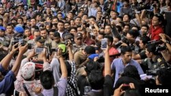 Dua pria gay dibawa oleh polisi Syariah sebelum pelaksanaan hukuman cambuk di Banda Aceh hari Selasa (23/5).