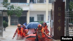 Rescue workers evacuate with an inflatable boat students stranded by floodwaters at a school, amid heavy rainfall in Duchang county, Jiangxi province, China July 8, 2020.
