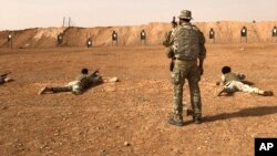 Members of the Maghawir al-Thawra Syrian opposition group receive firearms training from U.S. Army Special Forces soldiers at the al-Tanf military outpost in southern Syria on Monday, Oct. 22, 2018. 