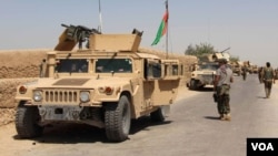 FILE - Afghan National Army troops arrive in the Nad Ali district of southern Helmand province, Aug. 10, 2016. An overnight airstrike in the area reportedly has killed at least 24.