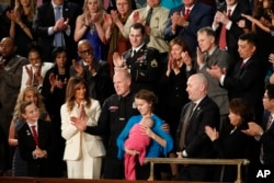 Albuquerque Police Officer Ryan Holets and his wife Rebecca acknowledge their introduction by President Donald Trump as they stand with first lady Melania Trump during the State of the Union address to a joint session of Congress on Capitol Hill in Washington, Jan. 30, 2018.