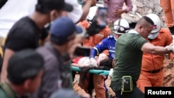 FILE - A rescue team carries a wounded worker at a collapsed building in Sihanoukville, Cambodia, June 22, 2019. 