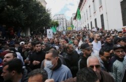 A demonstrator wearing a face mask marches with others during an anti-government protest, following the coronavirus outbreak, in Algiers, Algeria, March 6, 2020.