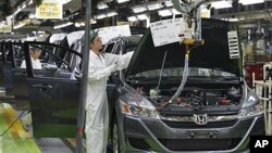 Workers give a final check on the Honda Accord Tourer at Honda Motor Co.'s Saitama Factory in Sayama, north of Tokyo, April 18, 2011