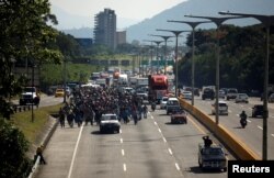 People walk in a caravan of migrants departing from El Salvador en route to the United States, in San Salvador, El Salvador, Oct. 31, 2018.