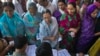 FILE - Voters get their names checked in a voter's lists at a polling station during the final phase of the general election in Varanasi in the northern Indian state of Uttar Pradesh.