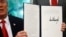U.S. President Donald Trump displays an executive order on immigration policy after signing it in the Oval Office at the White House in Washington, June 20, 2018.