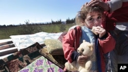 A Syrian child with her family, which fled from the Syrian town of Qusair near Homs, at the Lebanese-Syrian border village of Qaa, eastern Lebanon, March 5, 2012. 