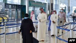 Des passagers au terminal 5 de l'aéroport international King Fahd, désigné pour les vols intérieurs, dans la capitale Riyad, en Arabie Saoudite, le 31 mai 2020, après que les autorités ont levé l'interdiction des vols dans le pays. (Photo par FAYEZ NURELDINE / AFP)