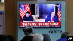A TV shows a photo of U.S. President Donald Trump and North Korean leader Kim Jong Un, left, while people listen to Kim's New Year's speech, at Seoul Railway Station in Seoul, South Korea, Jan. 1, 2019. 
