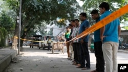 FILE - Bangladeshi police and detectives stand by the site where Italian citizen Cesare Tavella was gunned down by unidentified assailants in Dhaka, Sept. 29, 2015. Islamic State has claimed responsibility for the killing.