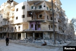 A man walks past damaged buildings in the rebel held besieged al-Sukkari neighbourhood of Aleppo, Syria, Oct. 19, 2016.