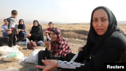 Displaced Kurds stuck at a border after a Turkish offensive in northeastern Syria, wait to try cross to the Iraqi side, at the Semalka crossing, next Derik city, Syria, Oct. 21, 2019.