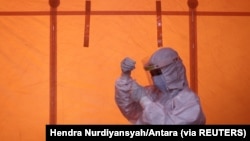 Seorang petugas kesehatan memegang sampel usap untuk tes antigen COVID-19, 3 Januari 2021. (Foto: Hendra Nurdiyansyah/Antara via REUTERS)