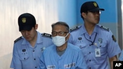 Former presidential chief of staff Kim Ki-choon, center, arrives at Seoul Central District Court in Seoul, South Korea, July 27, 2017.