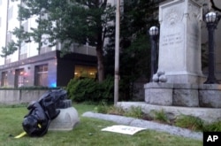 A toppled Confederate statue lies on the ground, Aug. 14, 2017, in Durham, N.C. Activists on Monday evening used a rope to pull down the monument outside a Durham courthouse. The Durham protest was in response to a white nationalist rally held in Charlottesville, Va.