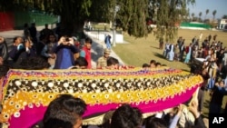 FILE - Relatives carry a casket with the body of journalist Malala Maiwand, who was shot and killed by gunmen, during her funeral in Jalalabad, east of Kabul, Afghanistan, Dec. 10, 2020.