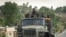 FILE - Government soldiers ride in the back of a truck, in Ethiopia, May 11, 2021.