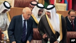 Arab League Secretary-General Nabil al-Arabi, left, talks to Qatari Foreign Minister Sheikh Hamad bin Jassim al- Thani, during an Arab foreign ministers meeting at the Arab League headquarters in Cairo to discuss the possibility of suspending Syria's memb