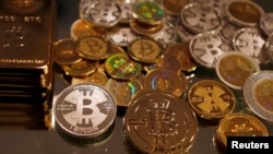 FILE - Bitcoins created by enthusiast Mike Caldwell are seen in a photo illustration at his office in Sandy, Utah, Sept. 17, 2013. 