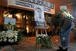 A man wearing a face mask attends a vigil for Chinese doctor Li Wenliang, in Hong Kong, Feb. 7, 2020.