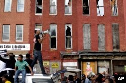 FILE - A protester leads marchers in a chant in front of blighted buildings in Baltimore, Maryland, May 2, 2015.