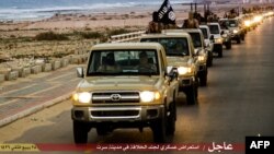 FILE - An image made available by propaganda Islamist media outlet Welayat Tarablos on Feb. 18, 2015, allegedly shows members of the Islamic State (IS) militant group parading in a street in Libya's coastal city of Sirte, which lies 500 kilometers (310 miles) east of the capital, Tripoli. 