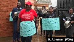 A group of men and women carry placards to confront the Uganda police at police headquarters as they protest the kidnapping and murder of women, June 5, 2018. 