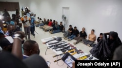 Les suspects de l'assassinat du président haïtien Jovenel Moise sont présentés aux médias, avec les armes et l'équipement qu'ils auraient utilisés lors de l'attaque, à la Direction générale de la police à Port-au-Prince, Haïti, jeudi 8 juillet 2021.