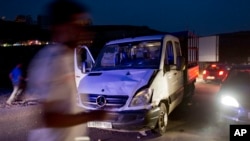Palestinian men inspect a vehicle with a bullet-shattered windshield at the site of a ramming attack against Israeli troops in the West Bank city of Ramallah, May 3, 2016.