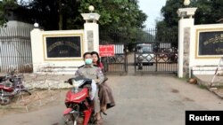 FILE - Prison staff members ride a motorcycle outside Insein Prison in Yangon, Myanmar, Jan. 3, 2019. 