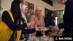 Tan Jakwani explains the sweets to customers at the Syrian Sweets Exchange event at Changing Hands Bookstore in Phoenix, Arizona.