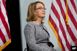 Former Arizona Rep. Gabby Giffords sits on stage as Democratic presidential candidate Hillary Clinton holds a rally at Iowa State University in Ames, Iowa, Jan. 30, 2016.