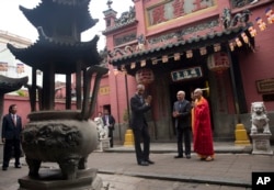 President Barack Obama stands with Thich Minh Thong, abbot of the Jade Emperor Pagoda, right, and Duong Ngoc Dung, professor at Ho Chi Minh City University of Social Sciences and Humanities, center, after visiting the Jade Emperor Pagoda in Ho Chi Minh Ci