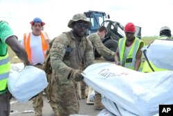 Members of the US army help load supplies at Beira International airport, Mozambique, Monday, April 1, 2019, joining the humanitarian aid efforts following a cyclone that hit the country on March 14.