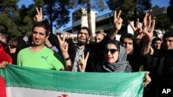 Warga Iran menanti kedatangan Menteri Luar Negeri Mohammad Javad Zarif yang kembali dari Lausanne, Swiss sembari mengacungkan tanda kemenangan atas kesepakatan nuklir, Jumat (3/4).