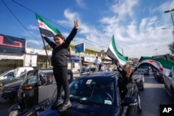 Syrians celebrate the fall of Bashar Assad's government in the town of Bar Elias, Lebanon, near the border with Syria, Dec. 8, 2024.