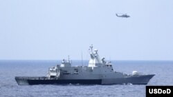 The Royal Malaysian Navy corvette KD Terengganu and a U.S. Navy MH-60R Sea Hawk helicopter conduct a coordinated air and sea search for a missing Malaysian Airlines jet in the Gulf of Thailand, March 12, 2014. (U.S. Navy photo by Operations Specialist 1st Class Claudia Franco)