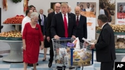 President Donald Trump pushes a cart during a tour of the Church of Jesus Christ of Latter-Day Saints Welfare Square food distribution center, Dec. 4, 2017, in Salt Lake City.
