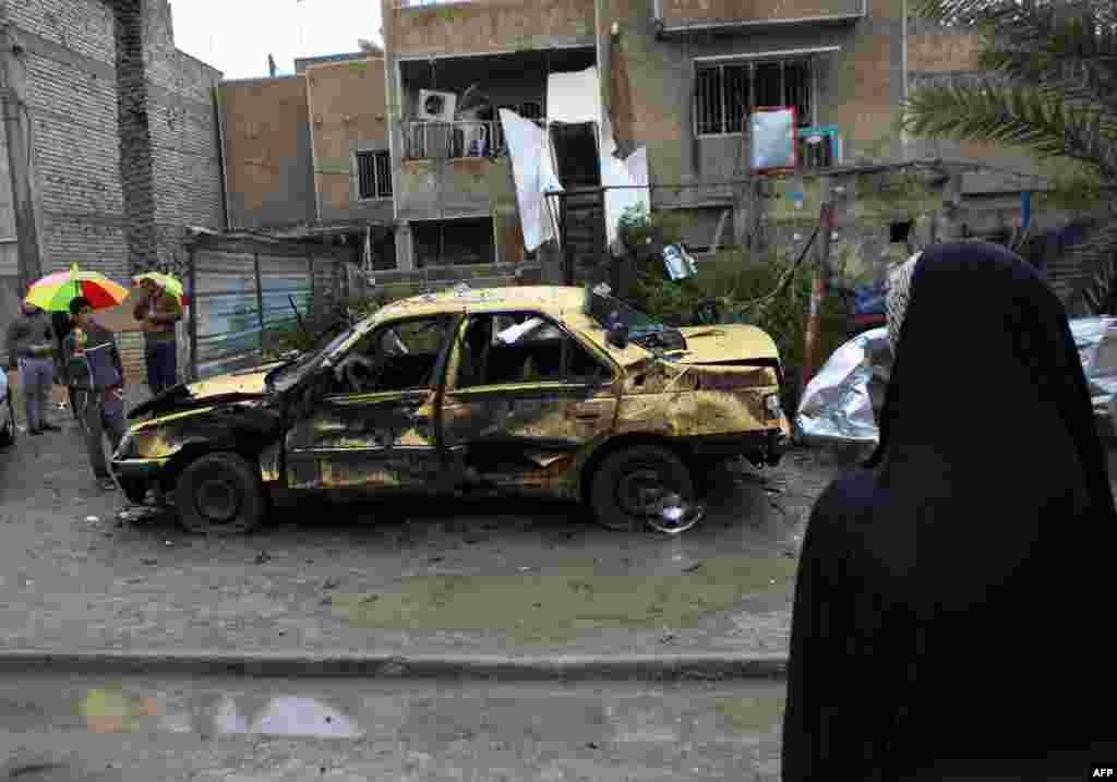 Local residents gather at the site of a car bomb explosion in the Hurriyah neighborhood of Baghdad, Feb. 3, 2014.