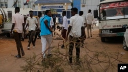 Pengunjuk rasa Sudan memblokir gang dengan cabang pohon, saat mereka bentrok dengan polisi anti huru hara saat protes, di Khartoum, Sudan. (Foto: AP)