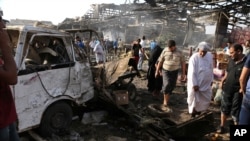 Civilians inspect the scene of bomb attack in Jameela market in the Iraqi capital's crowded Sadr City neighborhood Baghdad, Iraq, Thursday, Aug. 13, 2015.