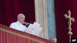 Pope Francis reads is message before delivering the Urbi et Orbi (Latin for 'to the city and to the world' ) Christmas' day blessing from the main balcony of St. Peter's Basilica at the Vatican, Dec. 25, 2019.