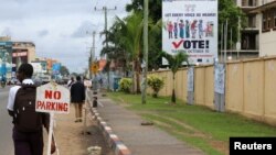 Warga berjalan melewati kantor pusat Komisi Pemilihan Umum Nasional Liberia di kawasan Sinkor , Monrovia, Liberia, 6 November 2017.