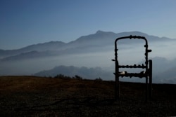 A charred lawn chair overlooks a valley filled with smoke from the Kincade Fire near Healdsburg, Calif., Nov. 1, 2019.